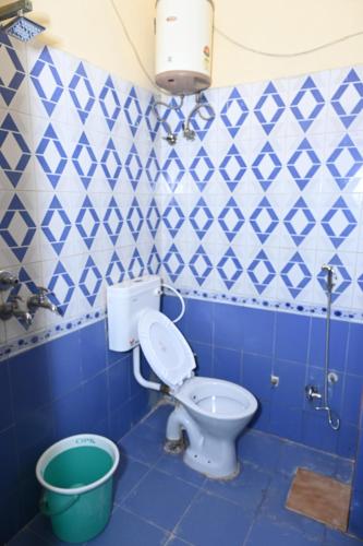 a blue and white bathroom with a toilet and a bucket at Hotel Heritage in Varanasi