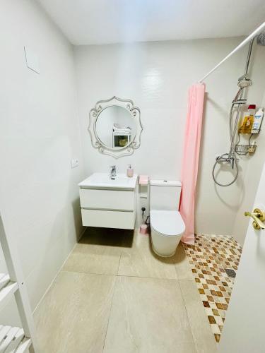 a bathroom with a toilet and a mirror on the wall at Villabett Caudiel está de moda in Caudiel