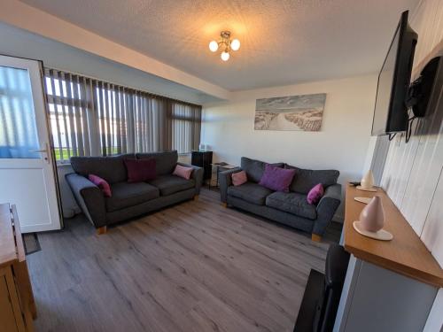 a living room with two couches and a tv at 319, Two bed newly refurbished chalet on Sund0wner Holiday Park - Sleeps 5, pet friendly - Includes electricity, bed linen and towels - Entertainment options close by in Hemsby