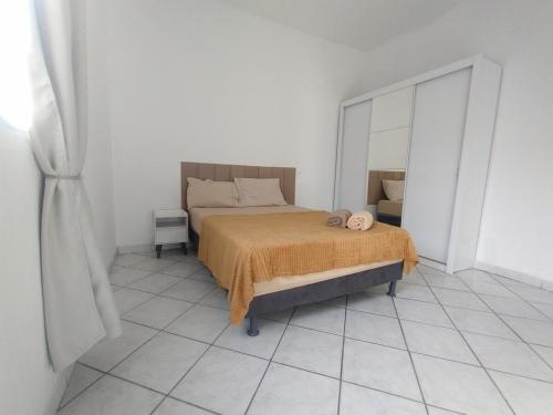 une chambre avec un lit et un grand miroir dans l'établissement AP Custo benefício a 10 min de praia,rodoviária, estádio e ferroviária, à Vila Velha