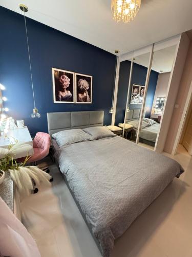 a bedroom with a large bed and a mirror at Komfort House apartament z tarasem in Ełk