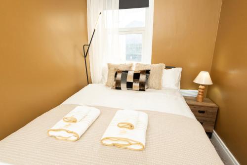 ミドルズブラにあるRio Apartmentsのタオルが敷かれた白いベッドのある寝室