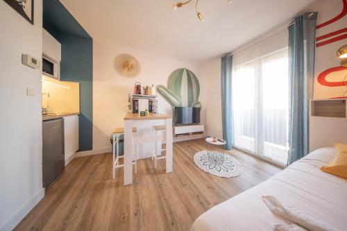 a bedroom with a bed and a desk and a kitchen at Magnifique Studio Illzach Centre in Illzach