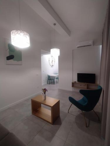 een woonkamer met een blauwe stoel en een tafel bij Apartments Lukas 5 in Zadar