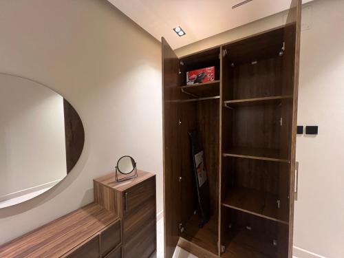 a room with a mirror and a wooden closet at سويت بغرفة نوم أنيقة وواسعة ودخول ذاتي in Hail