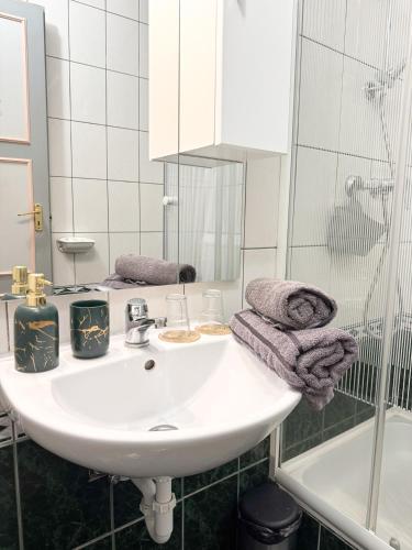 a bathroom with a white sink and a shower at Szent Kristóf Panzió in Eger