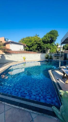 a small swimming pool with blue tiles in a yard at Casa na orla in Porto Seguro