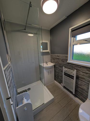 a bathroom with a shower and a sink and a toilet at 58, Two bed chalet on Sund0wner Holiday Park - Sleeps 4, pet friendly - Free WiFi plus electricity all included - Entertainment options close by in Hemsby