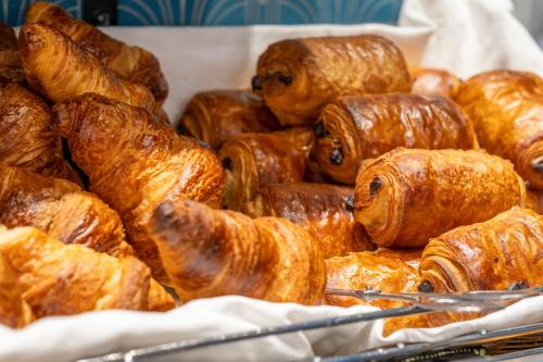 Best Western Hôtel d'Arc في أورليان: كومة من الكرواسون والمعجنات الأخرى على طاولة