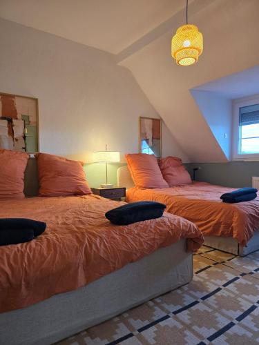 1 Schlafzimmer mit 2 Betten und orangefarbenen Kissen in der Unterkunft Modern Köln Flat 20mins Messe 25mins Neumarkt in Köln