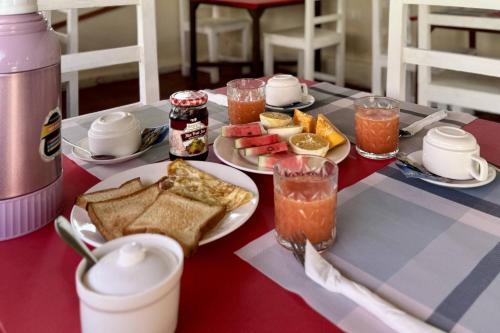 a table with plates of food and drinks on it at Zanzibar Lodge in Kiwengwa