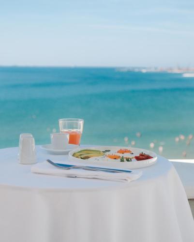 a table with a plate of food on the beach at Palace Hotel & SPA in Durrës