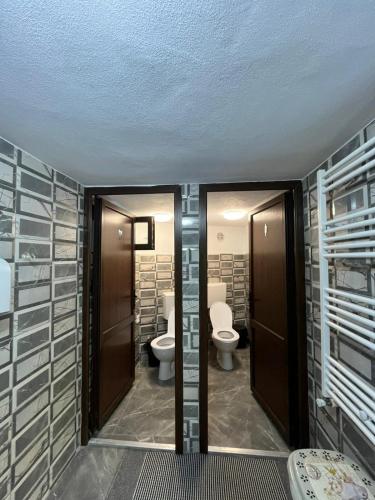 a bathroom with two toilets and two sinks at Cabana MARA in Poiana Vadului