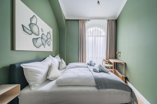 ein Schlafzimmer mit einem Bett mit weißen Laken und einem Fenster in der Unterkunft HOME1 - District 5 Boutique Hostel in Wien