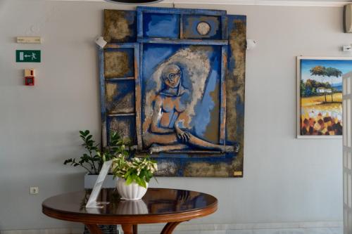 スカレタにあるRethymno Mare Royal & Water Parkのテーブル付き壁面女性絵画