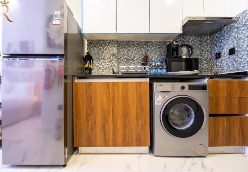 a kitchen with a washer and a washing machine at Bright Studio with Balcony the Gate, Masdar City in Abu Dhabi