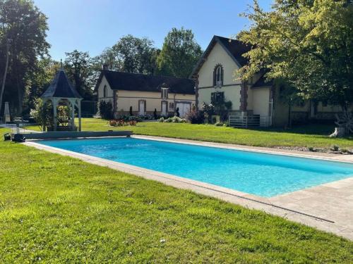 a house with a swimming pool in front of a house at La Chênaie - Suites individuelles dans un domaine d'art contemporain et nature in Gien