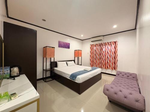 a bedroom with a bed and a purple chair at Clark stay in Fort Stotsenburg