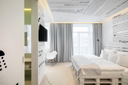 a white bedroom with a bed and a window at Pytloun Grand Hotel Imperial in Liberec