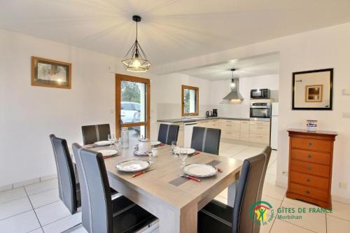 a dining room with a wooden table and chairs at Du golfe in Crach
