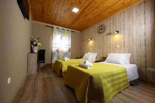 ein Hotelzimmer mit 2 Betten und gelber Bettwäsche in der Unterkunft Happy House in Faro
