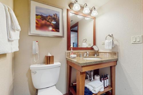Un baño con inodoro, lavabo y espejo. en 556 Everline, en Olympic Valley