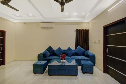 Una sala de estar con un sofá azul y una mesa. en Hotel O Neelkanth, en Jaipur