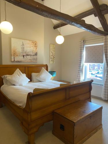 a bedroom with a large wooden bed with white pillows at Kezbah 1, 22 the square centre of Dalston village in Dalston