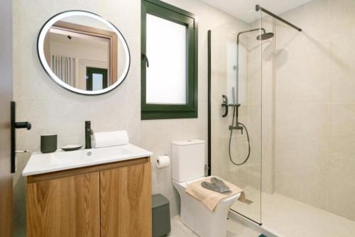 een badkamer met wastafel en douche met spiegel bij RoDous Luxury Apartments Preveza in Preveza