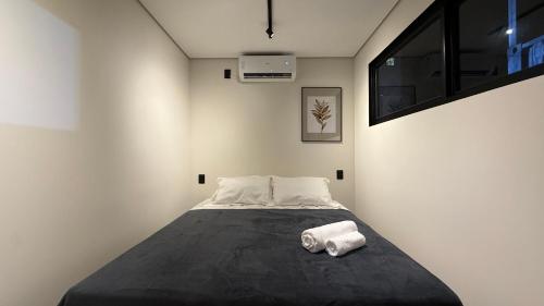 a bedroom with a bed with two towels on it at You Smart Flats in Formosa