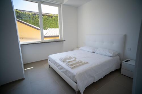 una camera da letto bianca con un letto e una finestra di 13 Nevoso Palace a Milano
