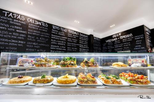 a display case filled with lots of different types of food at Hotel Marítimo Urban in Alicante