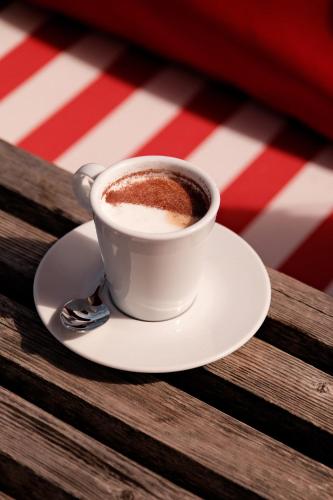 una taza de café en un plato sobre una mesa en Hôtel Ar Iniz, en Saint-Malo