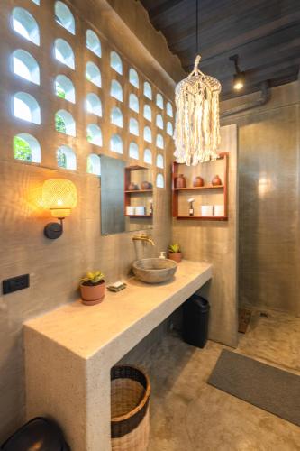 a bathroom with a counter with a sink and a chandelier at Anantha Wellness Sanctuary - Free Yoga & GYM in General Luna