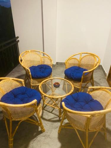 a group of chairs and a table with blue seats at Hotel Hanguk Villa in Dambulla