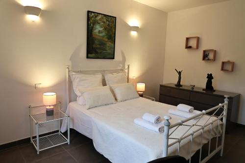 une chambre avec un lit blanc avec des serviettes dessus dans l'établissement Villa Lili Rose - Jacuzzi et Rivière à 3 min à pieds, à Zonza