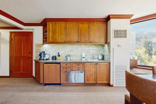 a kitchen with wooden cabinets and a large window at Resort at Everline Resort & Spa #560 in Olympic Valley