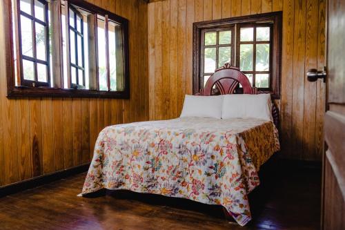 um quarto com uma cama com um cobertor e duas janelas em Romantic Refuge under the Stars, Villa BellaVista em Tamboril