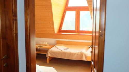 Habitación pequeña con 2 camas y ventana en Penzión Manín, en Považská Bystrica