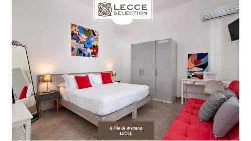 Un dormitorio con una cama blanca y un sofá rojo. en B&B Il Filo di Arianna - Lecce Selection, en Lecce