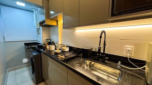 a kitchen with a sink and a counter top at Apartamento com aconchego e modernidade in Ribeirão Preto