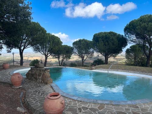 a swimming pool in the middle of a yard with trees at Villa Tiberini Wine Relais in Osteria Delle Noci