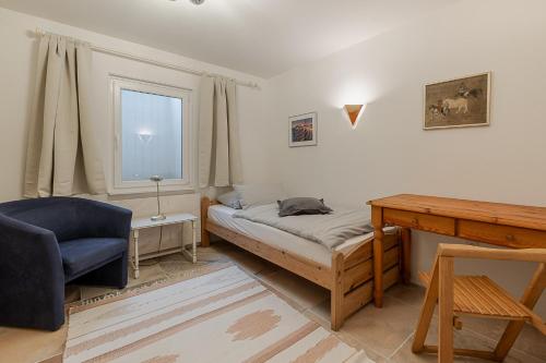 a bedroom with a bed and a desk and a window at Haus Wattblick EG in Braderup
