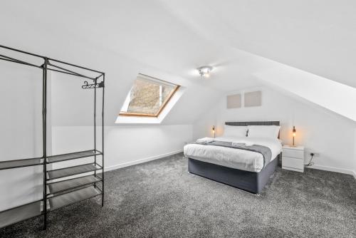 a white bedroom with a bed and a window at Comfortable 4 Bedroom Apartment - Hawick in Hawick