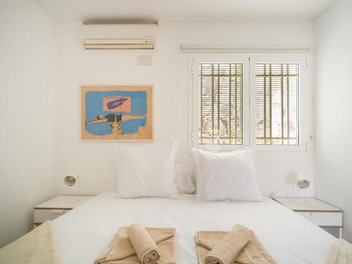 een witte slaapkamer met een bed met handdoeken erop bij Nueva Suecia By CanariasGetaway in San Agustin