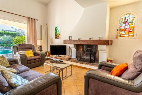 ein Wohnzimmer mit zwei Sofas und einem Kamin in der Unterkunft Nastidou in Sanary-sur-Mer