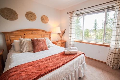 a bedroom with a bed and a large window at Sage & Pine Modern Townhome in Klamath Falls