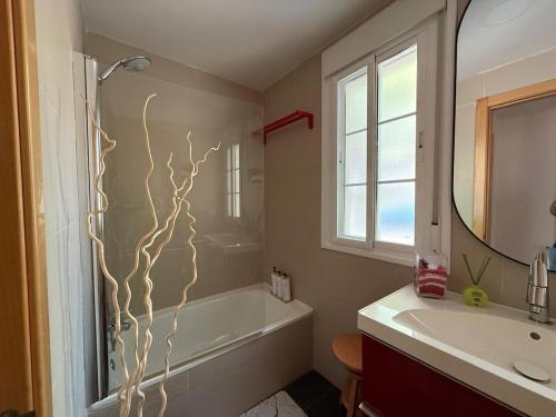 a bathroom with a tub and a sink and a mirror at Acogedor chalet con jardín ideal para desconectar in Sotillo de la Adrada