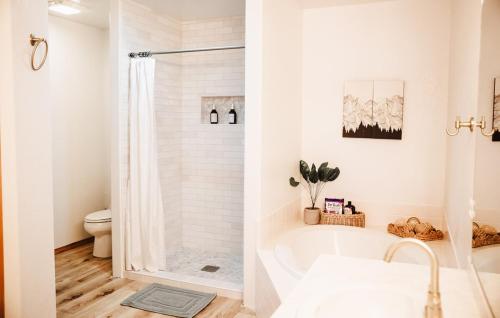 a white bathroom with a tub and a toilet at Sage & Pine Modern Townhome in Klamath Falls
