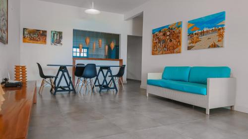 ein Wohnzimmer mit einem blauen Sofa und einem Tisch in der Unterkunft Casa Azul Maragogi in Maragogi
